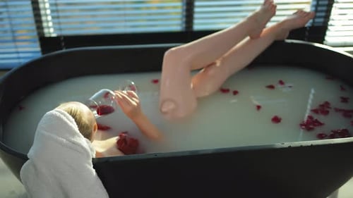 Spa Relaxation Woman Lying in Bath with Holding Glass with Red Wine Girl Relaxing in Bathroom at