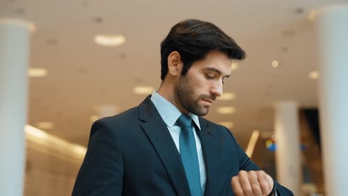 Confident Businessman Checking Time in Modern Lobby