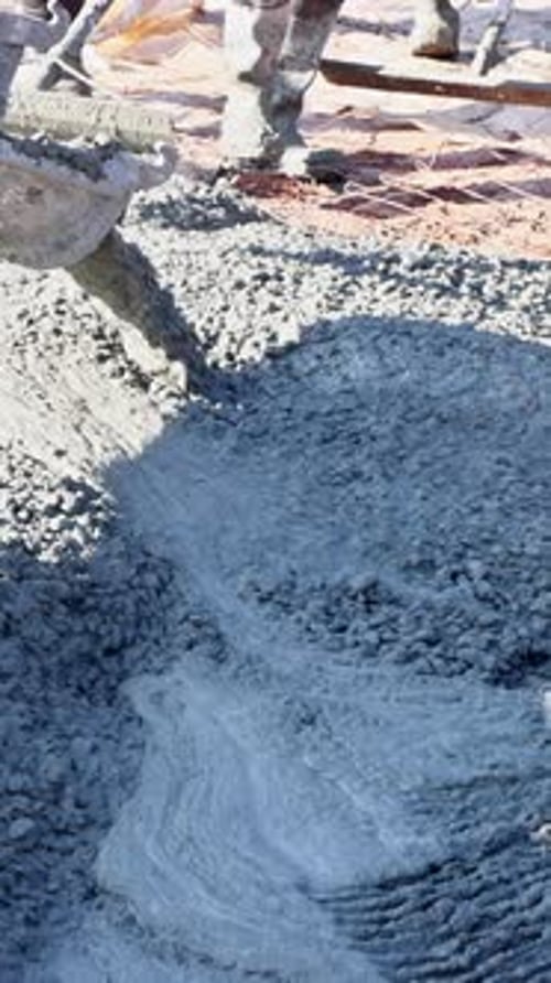 Workers Pour Spread Concrete at Construction Site