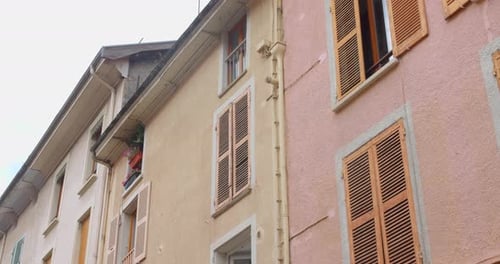 Colorful facades of old town buildings with wooden shutters in Vizille, France, daytime view