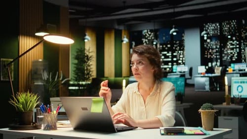 Woman working late at desk with laptop