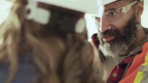 Construction workers discussing plans for redevelopment project in Canada