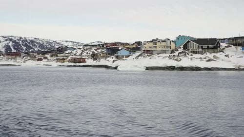Sea and Snowy Coast with Town in Greenland