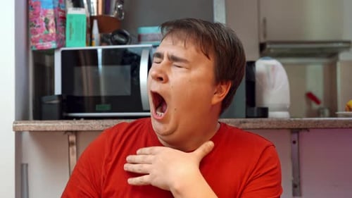 Young Adult Yawns Widely Indoors Close Up