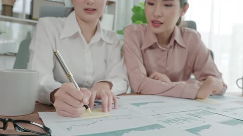 Two Young Enthusiastic Businesswoman Working Together in the Office Workspace
