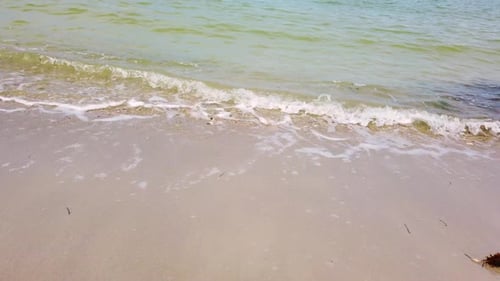 Waves Gently Washing onto a White Sand Beach