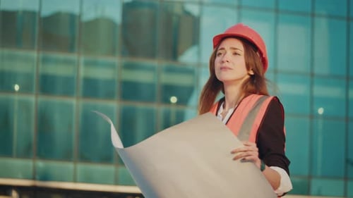 Portrait of a Successful Young Female Engineer or Architect Wearing a Orange Helmet