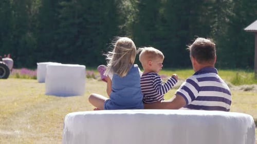 Grandfather and grandchildren enjoying sunny day in European farm scene, slow motion