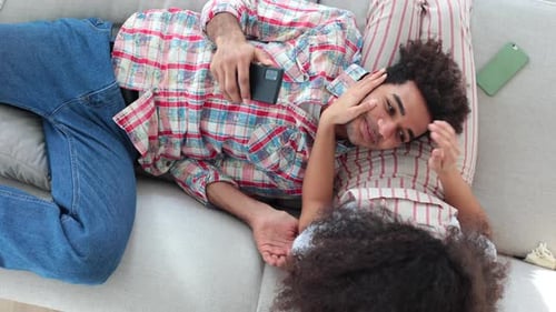 Relaxing Couple Laying on Couch at Home