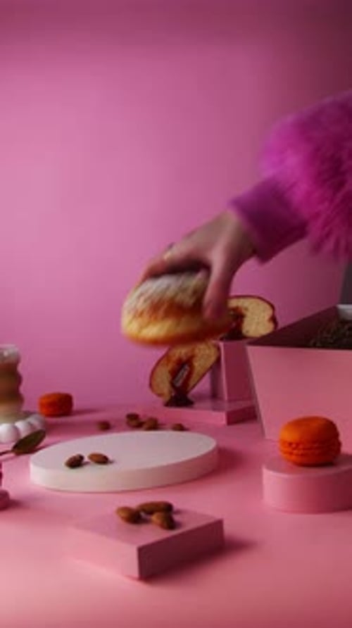 Donut and Macarons on Pink Background being Placed