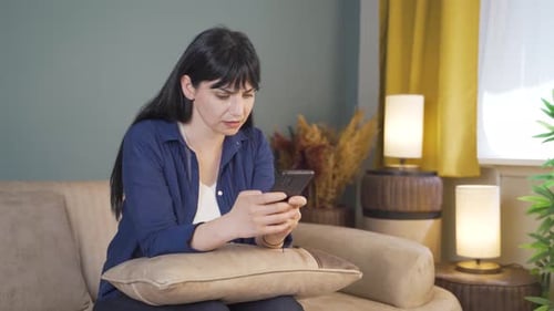 Young Woman Using Smartphone in Living Room