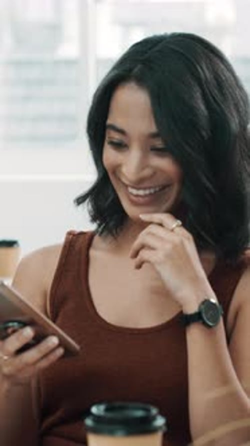 Woman Smiling Using Phone in Cafe