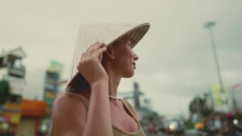 Beautiful Caucasian Female Tourist in Traditional Asian Hat Standing in City Portrait of Inspired
