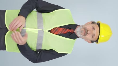 Vidéo verticale d'un vieil ingénieur applaudissant avec enthousiasme.