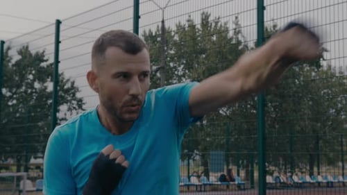 Focused Man Boxing On Outdoor Court