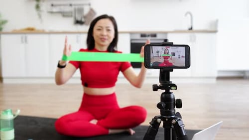 Woman Demonstrating Exercise Band Workout in Kitchen