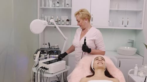 Aesthetician Performing Skincare Treatment on Reclining Woman