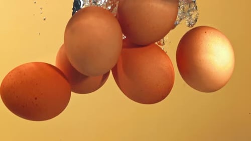 Eier in Superzeitlupe fallen mit Blasen unter Wasser