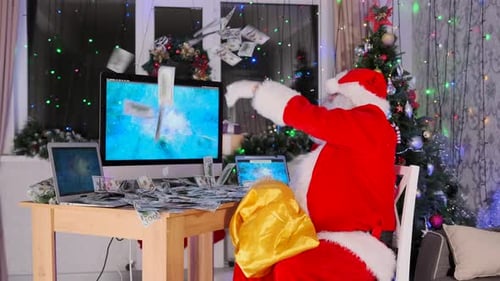 Santa in a red suit scatters dollar bills on his desk while sitting near a Christmas tree