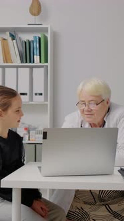 Girl and Doctor Discussing Laptop in Office