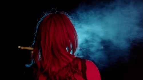Woman Exhaling Vapor at Night with City View