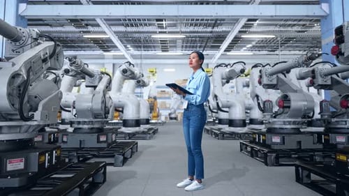 Woman Inspecting Robotic Arms in Modern Factory