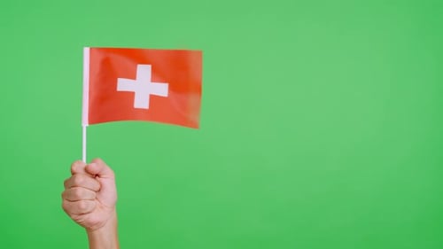 Hand Holding Switzerland Flag on Green Screen Background
