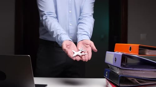 Businessman Presenting Model Airplane in Office Setting