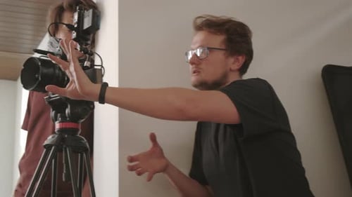 Two Men Filming with a Camera Indoors