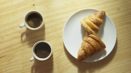 Coffee and Croissants on Light Wood Table