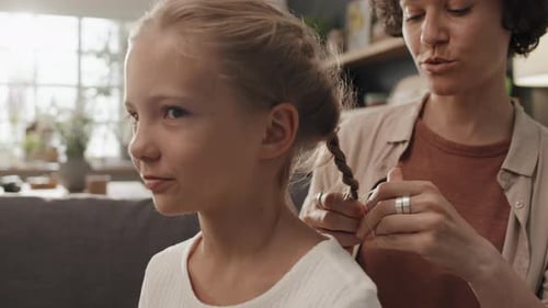 Woman Braiding Daughters Hair