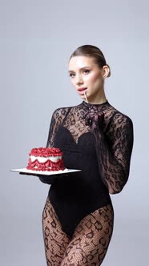 Elegant Woman Holding Birthday Cake with Lit Candle