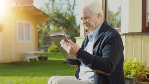 Senior Man Using Tablet Outside on Sunny Day