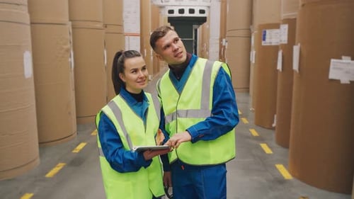 Fabrikarbeiter stehen im Lagerhaus einer Kartonverpackungsanlage