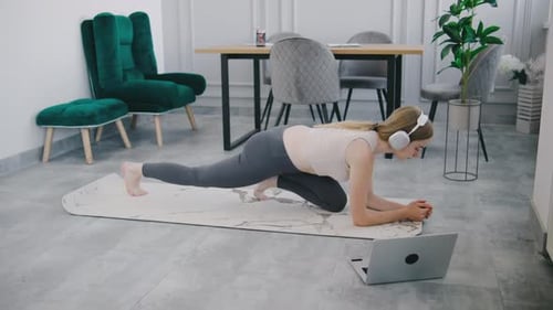 Woman Doing Exercises with Laptop at Home