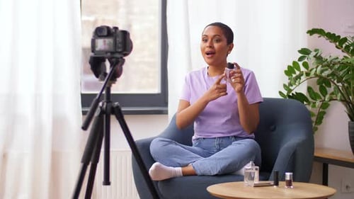 Woman sits and films beauty vlog indoors