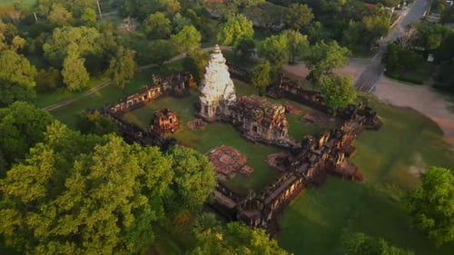 AERIAL: wide shot, flying around of an ancient temple in Thailand at dawn. Panning left to right.