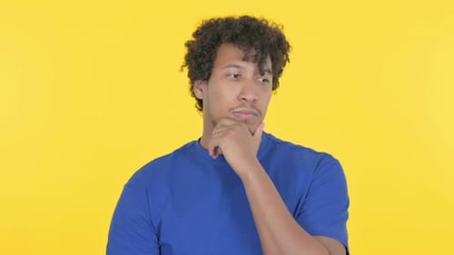 Young Adult Thinking Against Bright Yellow Background