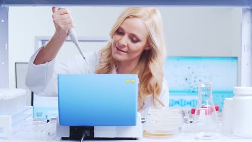 Woman Scientist Using Pipette in Modern Laboratory