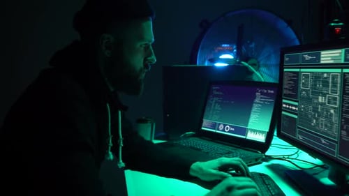 Bearded Man Coding at Computer in Dark Room