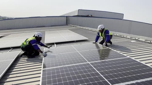 Technician installing solar cell. Installation and maintenance of solar cells on rooftop.