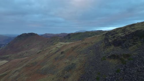 Fast flight over mountain shoulder revealing valley and mountains beyond. Lake District, Cumbria, UK