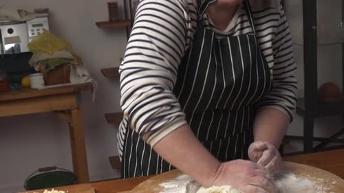 Eine kulinarische Frau knetet Hefeteig auf einem Schneidebrett