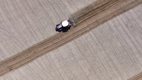 Tractor plowing the field - Red tractor plowing the field, 4k aerial shot with drone