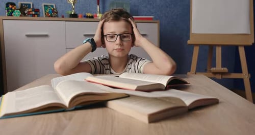 Stressed Boy Overwhelmed by Homework at Table