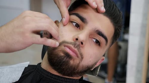 Portrait of a Man in a Barber Shop His Beard is Shaved with a Blade