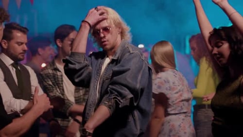 Young Adults Dancing at Party with Colorful Lighting