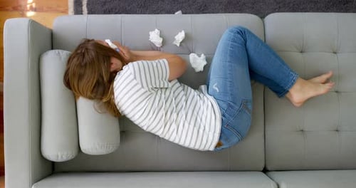 Woman Lying On Couch With Tissues Overhead View
