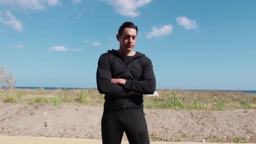 Man Stands Crossed Arms by Beach