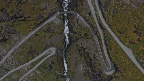 Vista aérea da estrada Trollstigen enquanto os veículos percorrem curvas íngremes